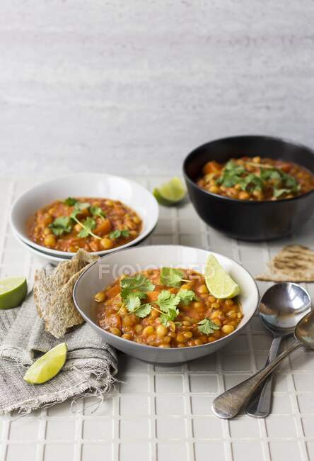 Harira soup with lime wedges and coriander — Stock Photo