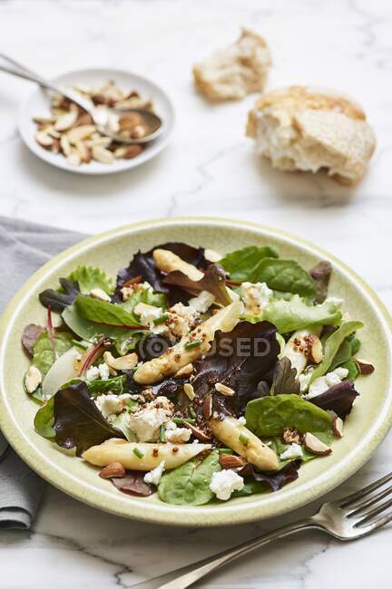 Mixed leaf salad with white asparagus tips and sheep's cheese — Stock Photo