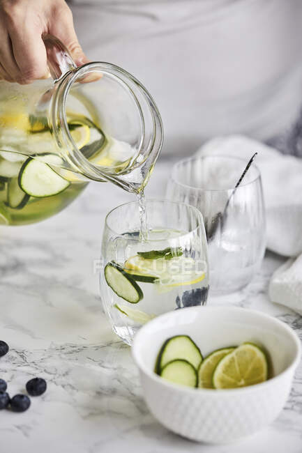 Pouring fresh cold infused water into a glass — Stock Photo