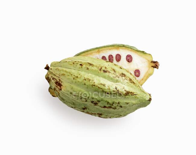 Uma fruta de cacau fatiada na frente de um fundo branco — Fotografia de Stock