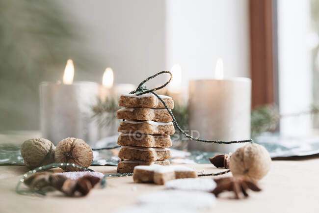 Cinnamon stars with burning candles in the background — Stock Photo