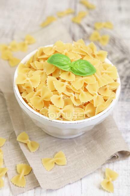 Farfalle pasta in a bowl with fresh basil — Photo de stock