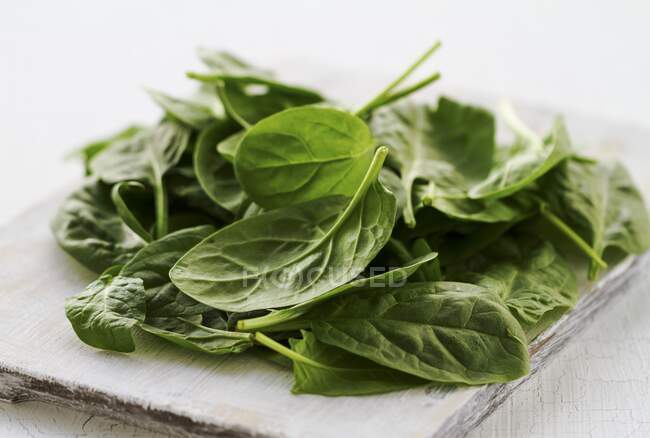 Fresh spinach leaves on a chopping board — Stock Photo