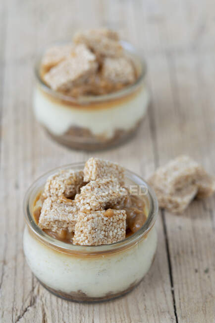 Cheescakes in jar with caramel and sesame bar — Stock Photo