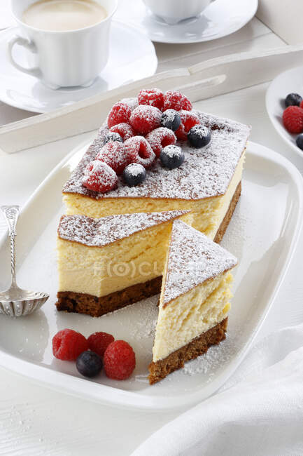 Cheesecake with powdered sugar and fruit — Stock Photo