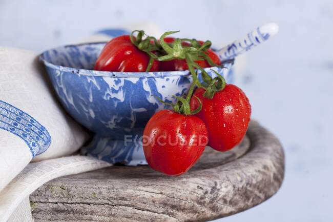 Pequenos tomates de ameixa em uma tigela de cerâmica — Fotografia de Stock