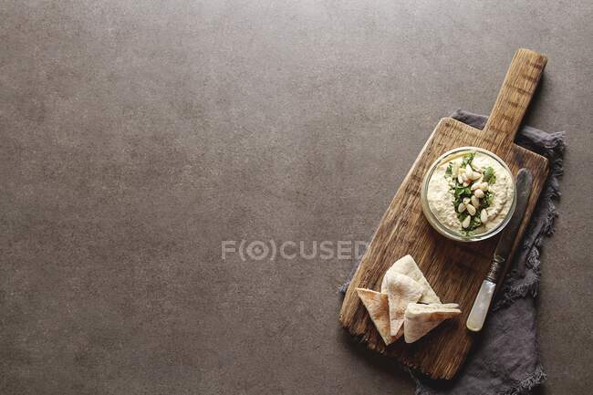 Hummus clássico com ervas, azeite em jarra de vidro e lavash, cozinha tradicional do Oriente Médio — Fotografia de Stock