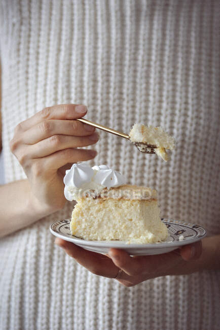 Mulher está segurando um prato com um pedaço de cheesecake — Fotografia de Stock
