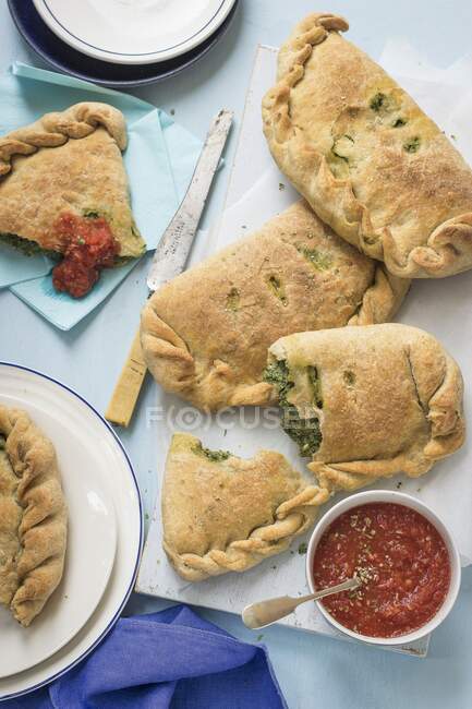 Spinach and ricotta calzone with tomato sauce — Stock Photo