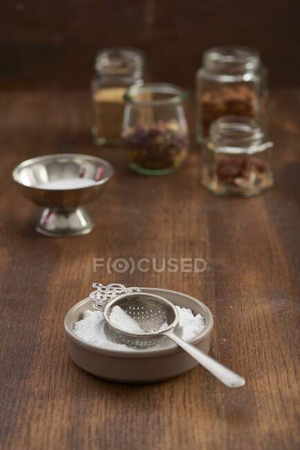 Icing sugar with a vintage sieve in a ceramic bowl — Stock Photo