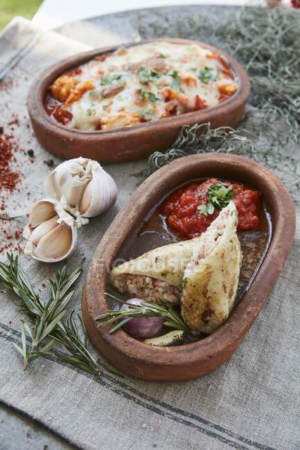 Stuffed squid and a seafood bake in serving bowls — Stock Photo