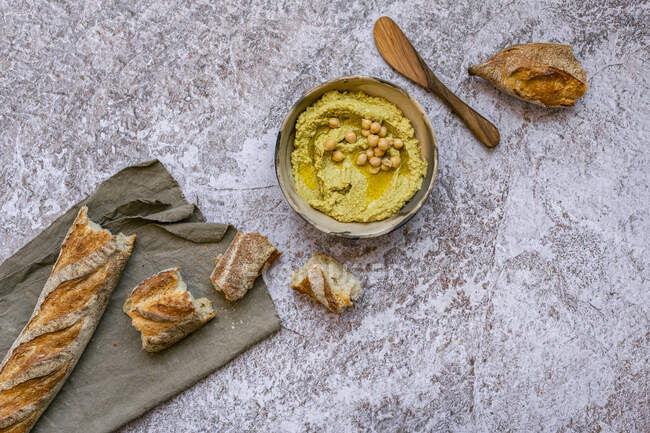 Hummus à l'avocat végétalien avec baguette déchirée — Photo de stock