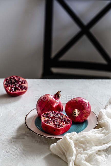 Pomegranate seeds and red garnet on a wooden table — Stock Photo
