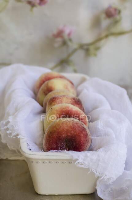 Donut-Pfirsiche auf weißem Tuch — Stockfoto