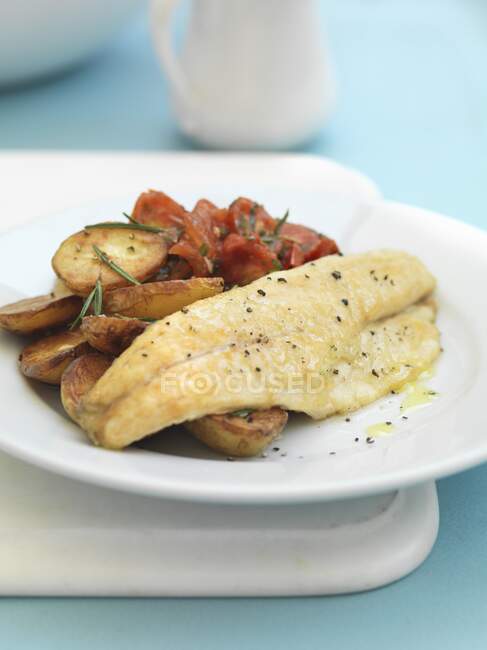 Sea bass with fried potatoes and tomatoes — Stock Photo