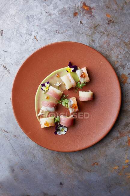 Роллы суши на тарелке, украшенные съедобными цветами — стоковое фото