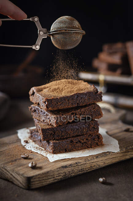 Brownies sendo polvilhado com cacau — Fotografia de Stock