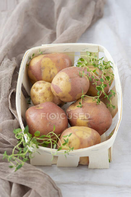 Uncooked potatoes in basket — Stock Photo