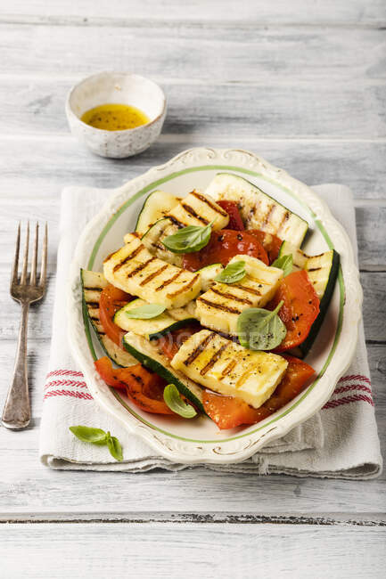 Grilled halloumi salad with zucchini, peppers, tomatoes and basil — Stock Photo