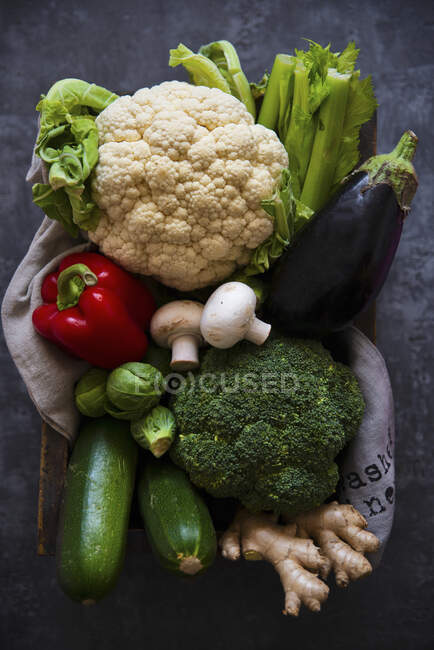 Коробка свежих овощей - цветная капуста, брокколи, сельдерей, цуккини, баклажаны, грибы и красный перец — стоковое фото