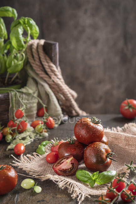 Tomates frescos con gotas de agua en una mesa de madera - foto de stock