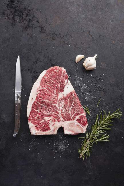 A raw beef steak on a black background (top view) — Stock Photo