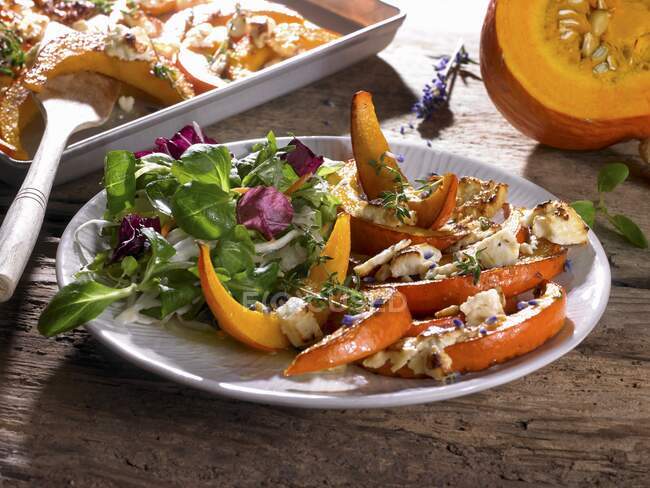 Oven-baked pumpkin wedges with feta and side salad — Stock Photo