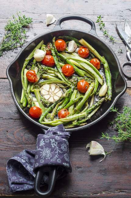 Fried asparagus with garlic and cherry tomatoes — Stock Photo