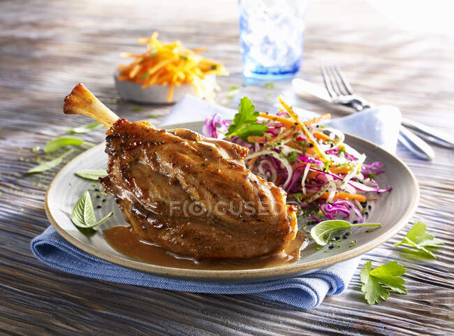 Pork knuckle with coleslaw served on table — Stock Photo
