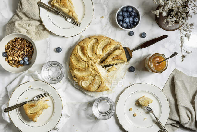 Tisch mit glutenfreien veganen Apfelkuchenscheiben Müsli-Beeren — Stockfoto