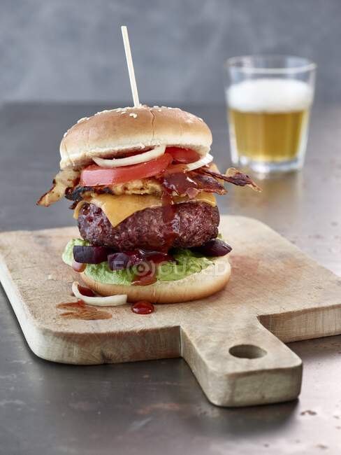 Hambúrguer de carne com cheddar, bacon e molho de churrasco — Fotografia de Stock