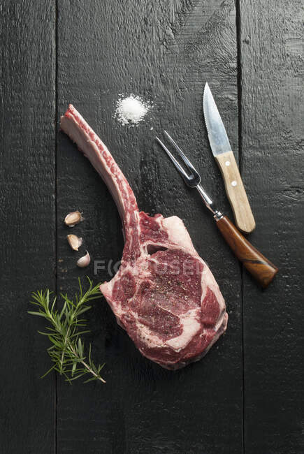 Roh Tomahawk Steak mit Rosmarin und Knoblauch — Stockfoto