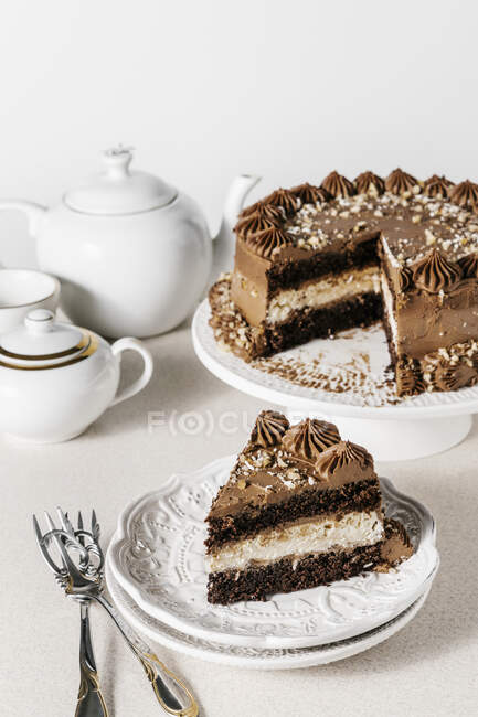 Chocolate cake with vanilla and coconut cheesecake layer and chocolate frosting — Stock Photo