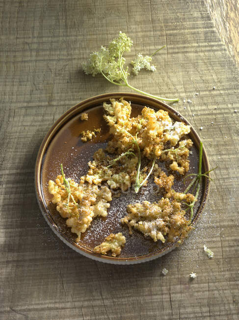 Hollerkchle (deep-fried elderflowers) on a plate — Stock Photo