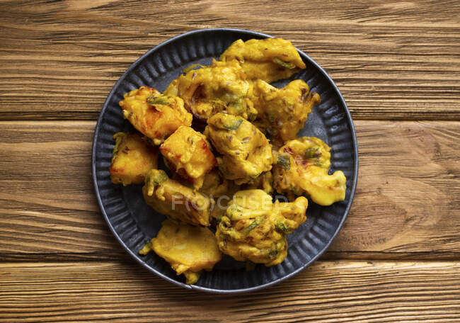 Indian fried assorted pakoras on wooden rustic background — Stock Photo