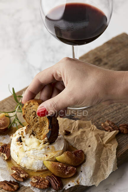 Выпеченные бри со свежим инжиром и медом, подаются с бокалом красного вина — стоковое фото