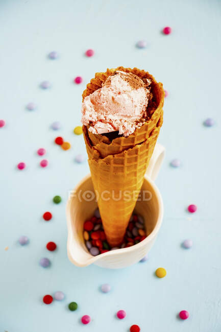 Ice cream in waffle cone with smarties — Stock Photo