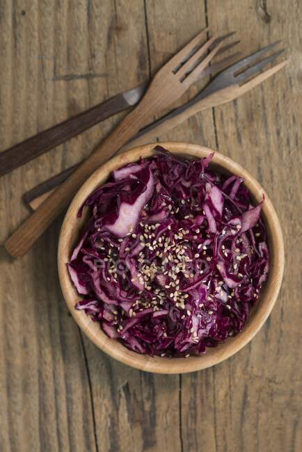 Red cabbage salad with sesame seeds in wooden bowl — Stock Photo