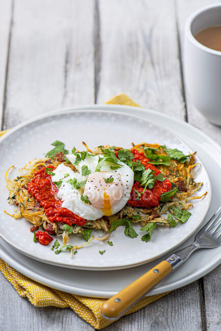 Potato rosti with chorizo, coriander, red pepper dip and poached egg — Stock Photo