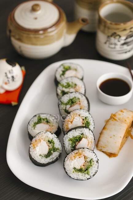 Maki sushi with soy sauce on serving plate — Stock Photo