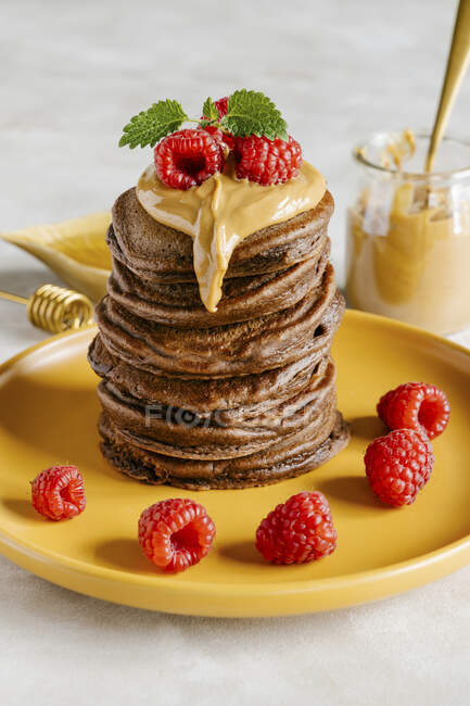 Chocolate pancakes with peanut butter and raspberry — Stock Photo