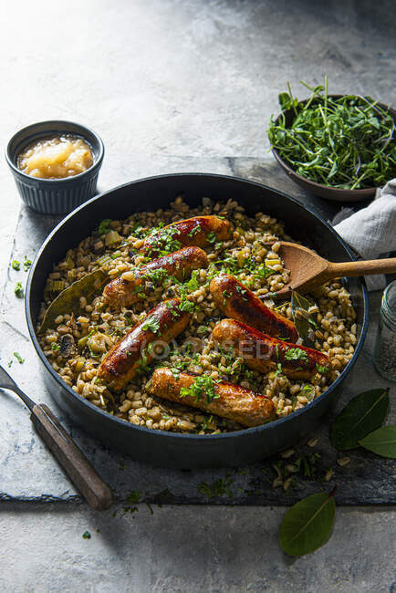 Pearl barley with mushrom, celery and grilled sausages — Stock Photo