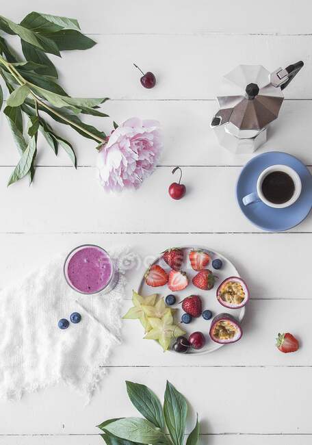 Fresh fruits served on a plate with coffee and a smoothie — Stock Photo
