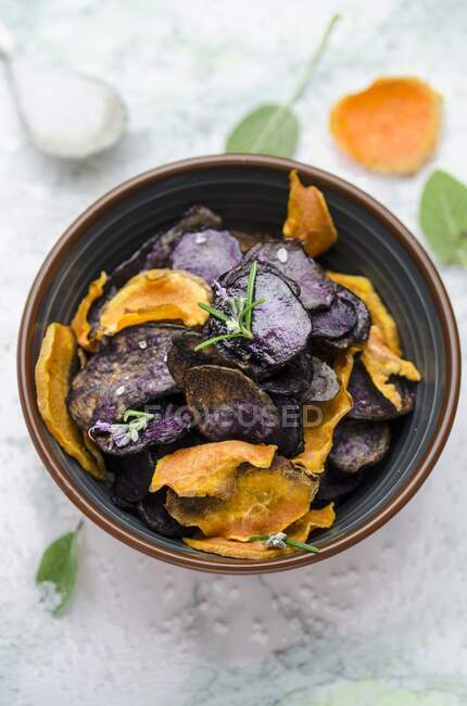 Homemade sweet potato and blue potato crisps in mini bowl — Stock Photo