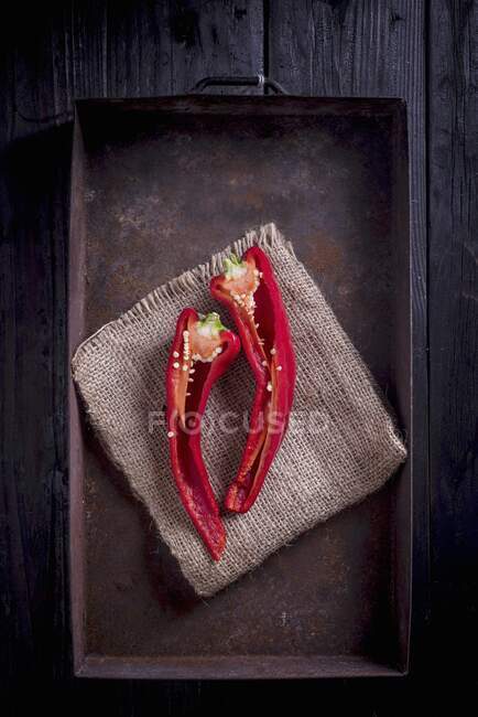Un chile rojo fresco cortado por la mitad - foto de stock