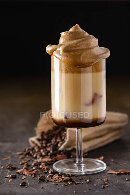 Iced milk coffee with espresso beans and frothy coffee — Stock Photo