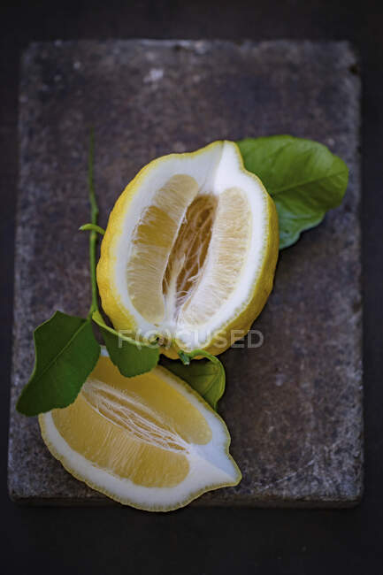 Vista de cerca de limón en rodajas con hojas - foto de stock