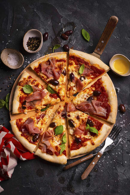 Pizza mit Mozzarella, Parmaschinken, Oliven und Basilikum — Stockfoto