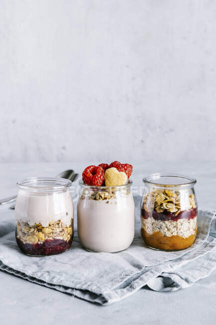 Healthy raspberries parfaits with yogurt in glass jars — Stock Photo