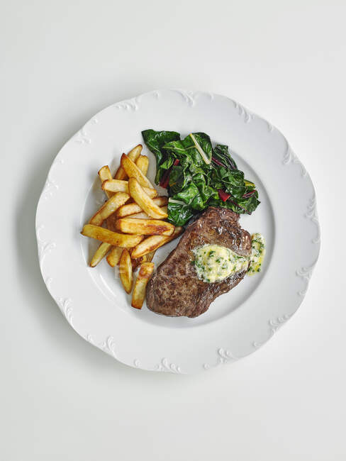 Steak de boeuf aux herbes beurre, salade et frites — Photo de stock